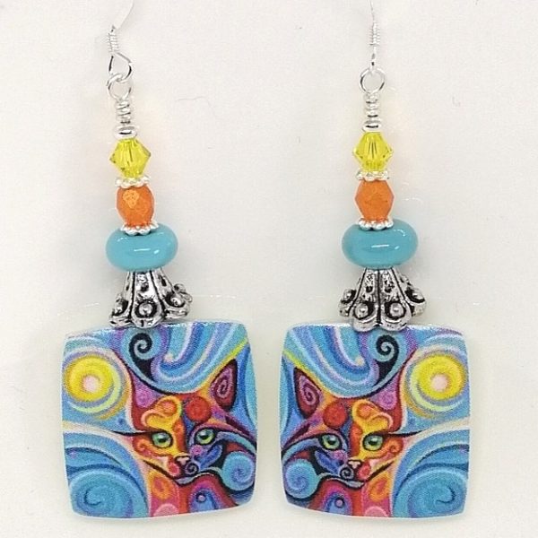 Colourful porcelain earrings with a cat face made by Wendy Lindsay